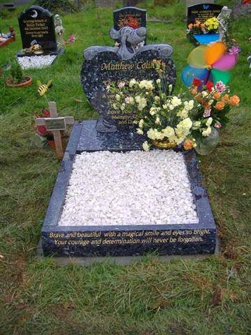 Black granite child's memorial with white chippings and flowers