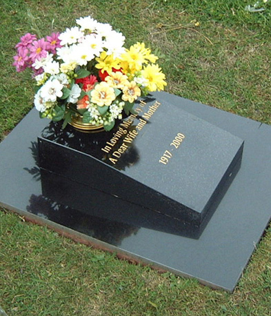 Black granite book memorial with flowers