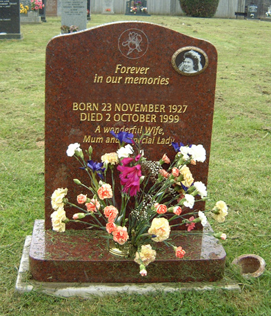 Red granite headstone with flowers