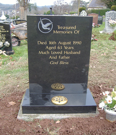 Black granite headstone with a carved dove
