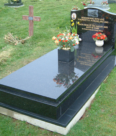 Polished black granite kerbset memorial in a cemetery