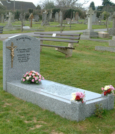 Grey granite headstone with full kerbset in a cemetery